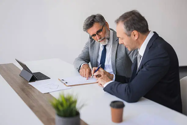 Business meeting with colleagues analyzing charts and reports at a conference table.